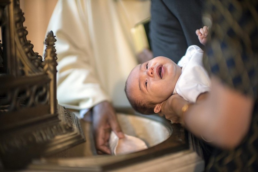 1078px-A_baby_being_baptised_(15909273062).jpg