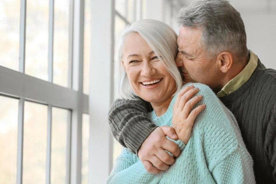 joyful-older-couple-hugging-and-laughing-in-bright-room..jpg