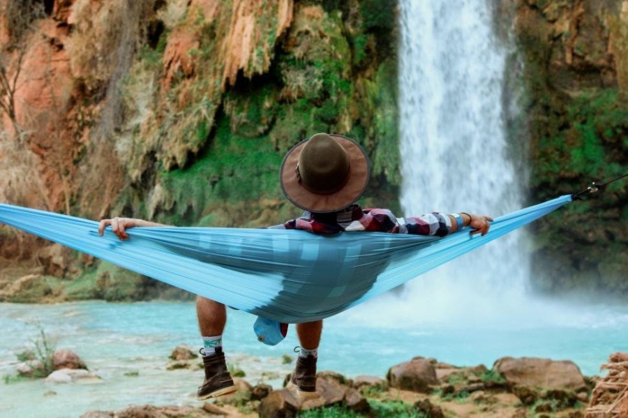 man-relaxing-on-hammock-with-waterfall-in-forest.jpg